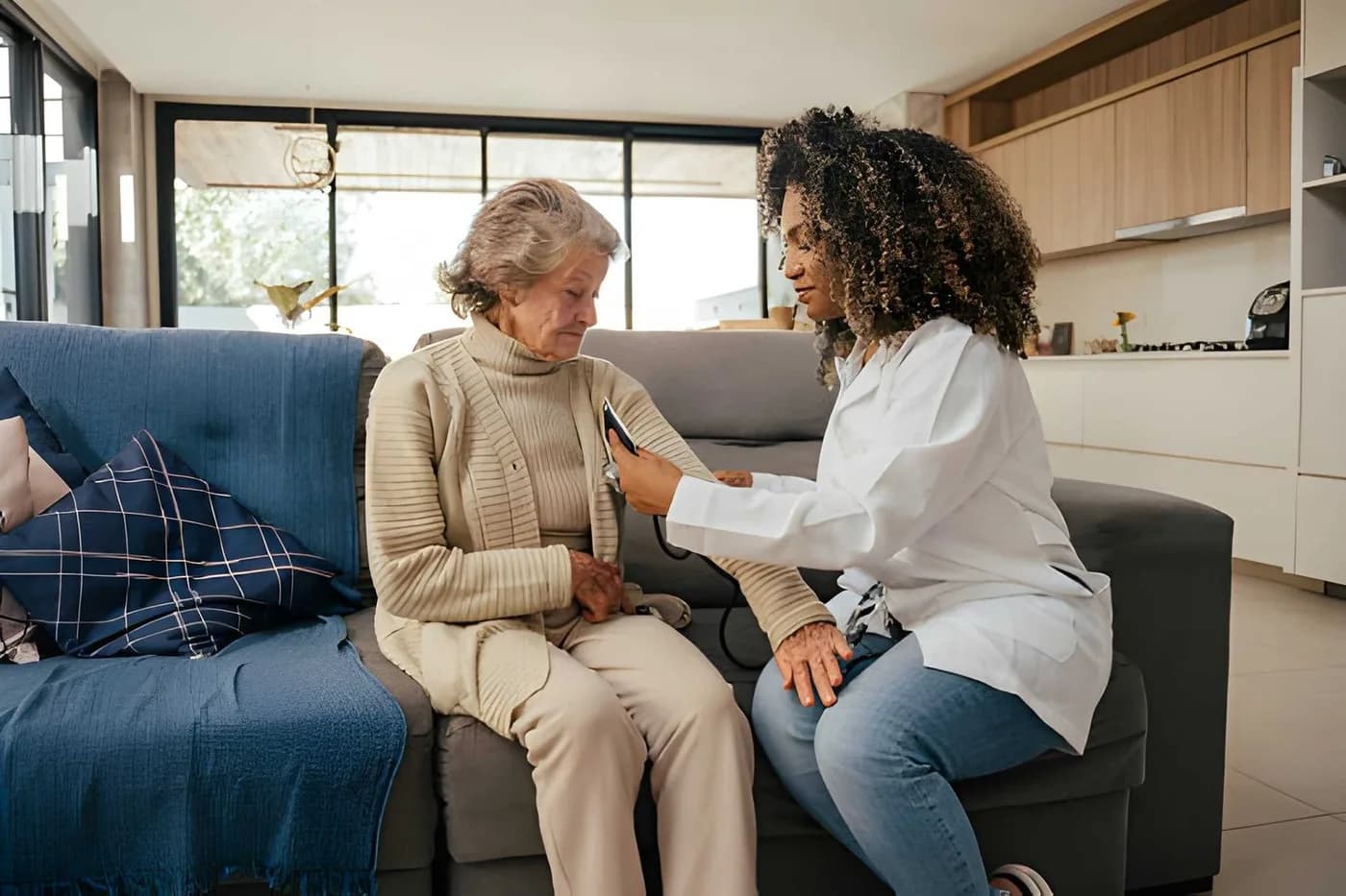 A care professional listening to an older adult during a conversation at home
